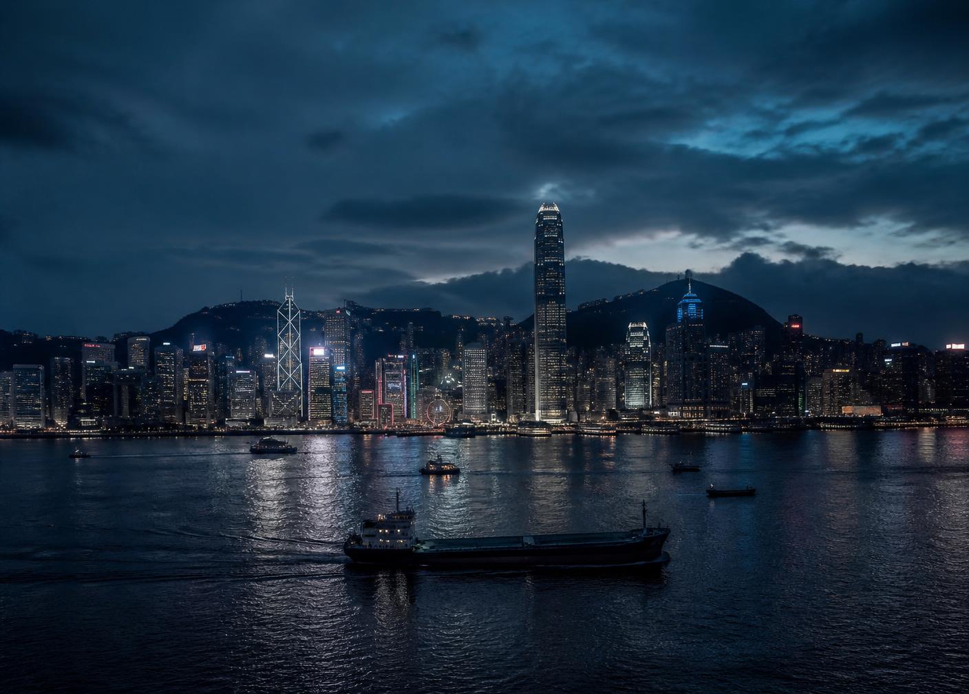 Hong Kong Victoria Harbour skyline at dusk with cargo vessels